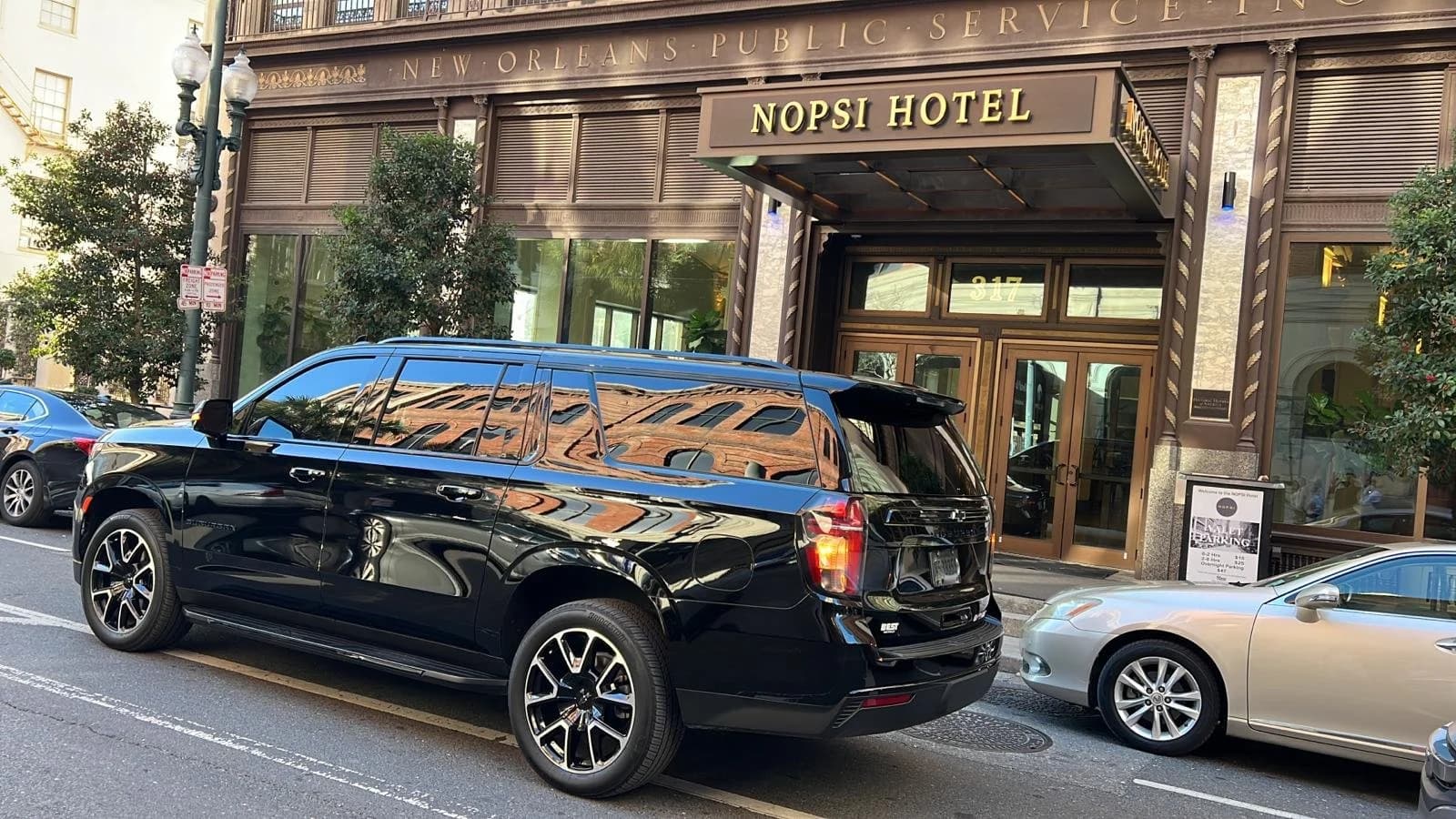 Black chauffeured SUV arriving at hotel entrance